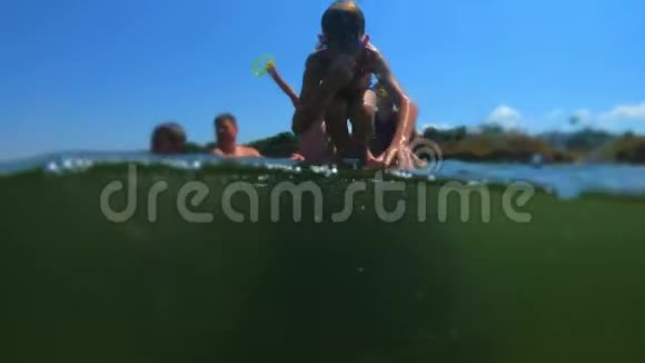 年轻英俊的男孩跳到海里孩子们跳进了翻筋斗的海里青少年跳进水里游泳视频的预览图