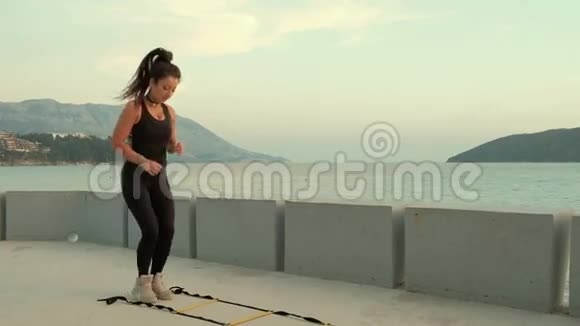 女运动员在海岸上用皮带的特殊模板跳跃视频的预览图
