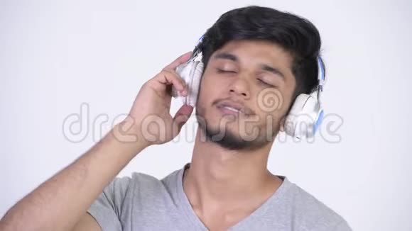 年轻快乐留胡子的印度男人听音乐视频的预览图