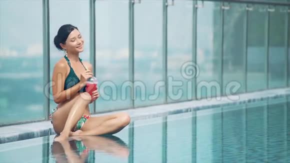 在泳池边喝新鲜冰沙的女孩视频的预览图