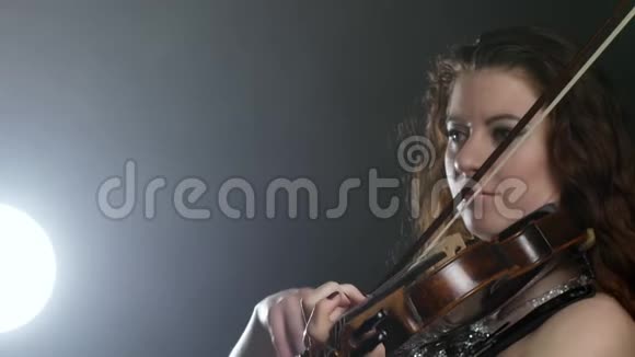 交响乐团女孩正在泛光照明中演奏乐器视频的预览图
