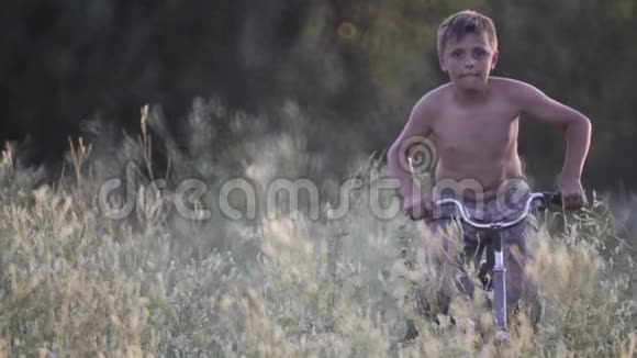 孩子们在一个村庄里休息骑着自行车在高高的草地上视频的预览图