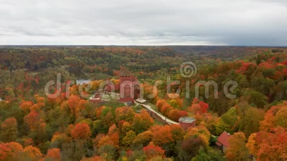 鸟瞰古老的图拉伊达城堡的秋天景观周围环绕着五颜六色的森林明亮的黄橙和绿色树木视频的预览图