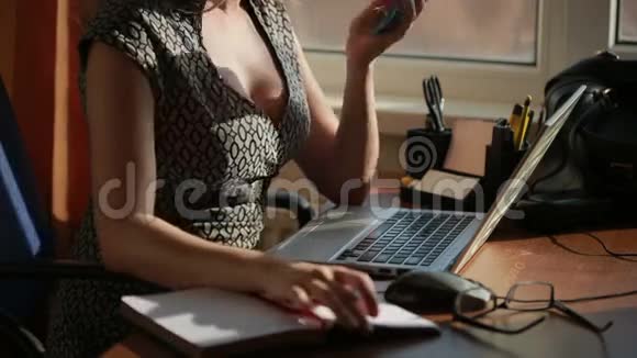 为一台笔记本电脑工作的女商人在电话里聊天视频的预览图