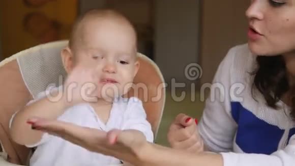 年轻的快乐母亲在婴儿座位上和她的新生儿玩耍家里的家人美丽的微笑妈妈视频的预览图