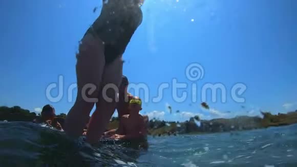 年轻英俊的男孩跳到海里孩子们跳进了翻筋斗的海里青少年跳进水里游泳视频的预览图