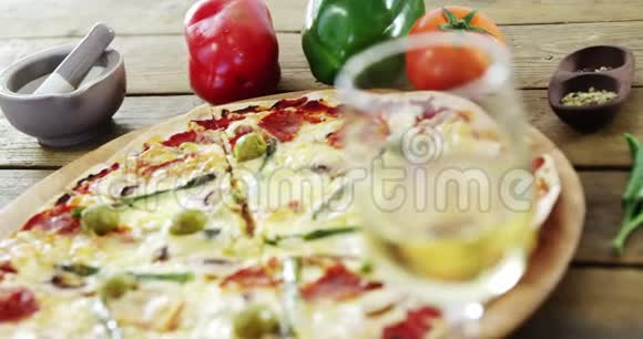 美味的披萨有一杯葡萄酒蔬菜和香料视频的预览图