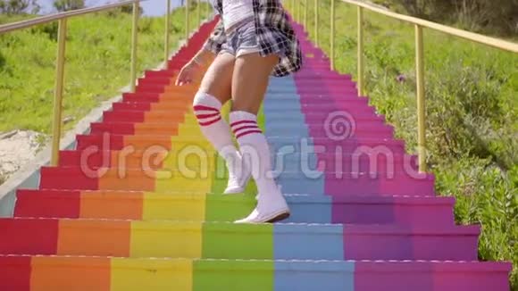 年轻女子降彩虹彩色台阶视频的预览图