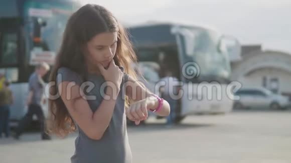 小女孩看慢动作视频智能互联网时钟社交媒体公共汽车站的少女离开视频的预览图
