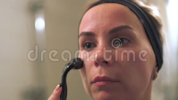 年轻的女人用真皮滚筒做脸滚筒微针中间疗法视频的预览图