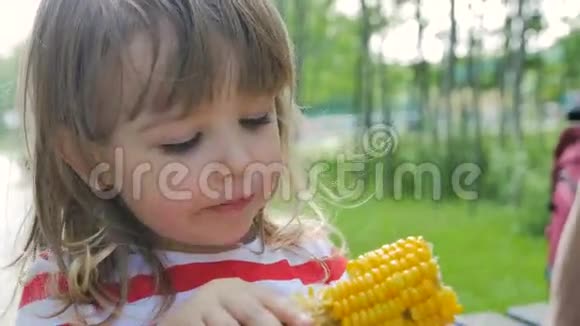 阳光明媚的女孩玉米快乐地吃水果视频的预览图