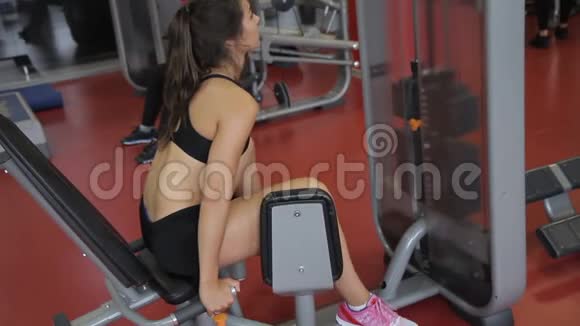 年轻女子运动员在室内健身房锻炼腿部视频的预览图