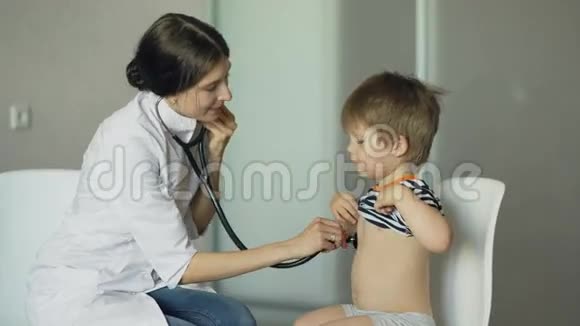 年轻女子医生用听诊器听小男孩说话视频的预览图