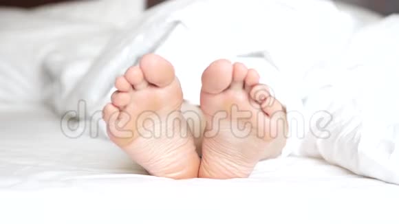 精致的雌性脚在白色床上嬉戏地移动脚趾视频的预览图
