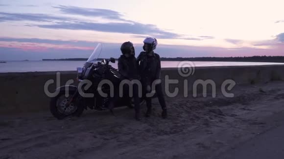 晚上两个年轻的骑自行车的人在河堤上放松视频的预览图