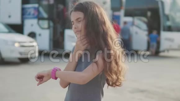 小女孩看智能慢动作视频互联网时钟社交媒体公共汽车站的少女离开视频的预览图