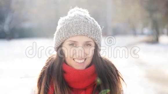 冬天阳光明媚的日子里美丽的微笑女孩视频的预览图