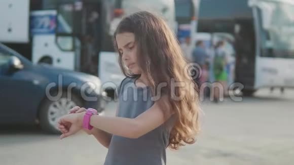 小女孩看慢动作视频智能互联网时钟社交媒体公共汽车站的少女离开视频的预览图
