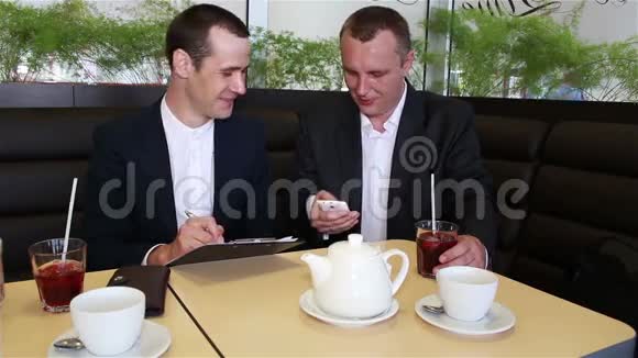 两个商人把智能手机上的数据写在文件里视频的预览图