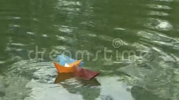 三艘彩色纸船漂浮在河上视频的预览图