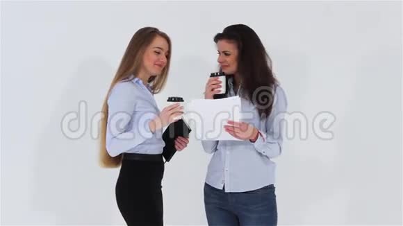 两个微笑迷人的办公室女孩喝咖啡空白A4纸视频的预览图