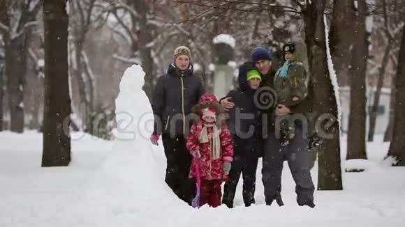 有许多孩子的幸福家庭他们堆雪人视频的预览图
