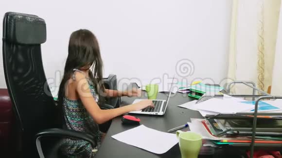 女孩在笔记本电脑上倒了茶做作业在线学习4K特写视频的预览图