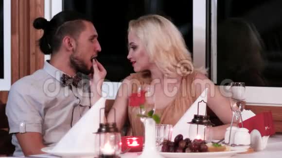 浪漫的约会在餐厅里相爱的夫妻晚上在浪漫的气氛中为恋人男孩和女孩视频的预览图