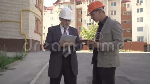 两位商人讨论在建筑附近建筑的方案4K视频的预览图