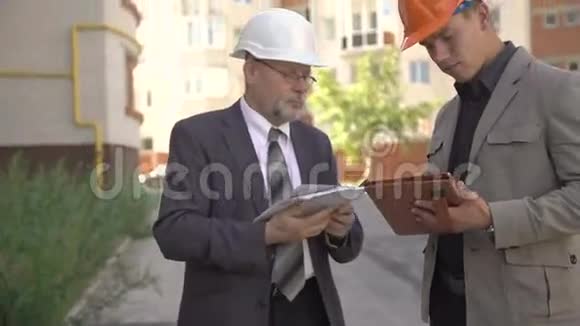 两个商人在头盔中讨论建筑附近的方案4K视频的预览图