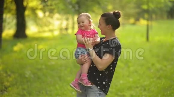 美丽的母亲在户外玩耍女人抱着她的孩子视频的预览图