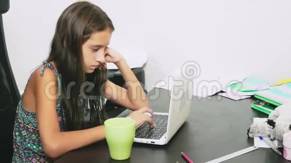女孩在笔记本电脑上倒了茶做作业在线学习4K特写视频的预览图