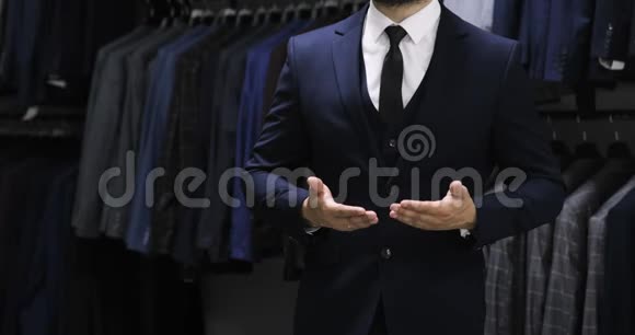 扣上一件夹克穿西装的时髦男人展示触摸屏手势关门视频的预览图