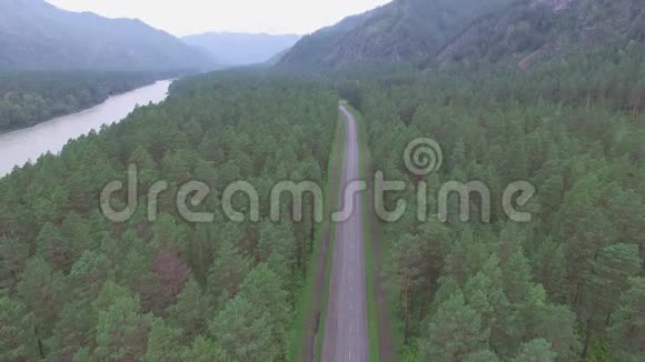 空中摄影在树林里的路上用无人机山区视频的预览图