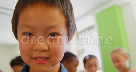 快乐的亚洲小学生站在学校的教室里视频的预览图
