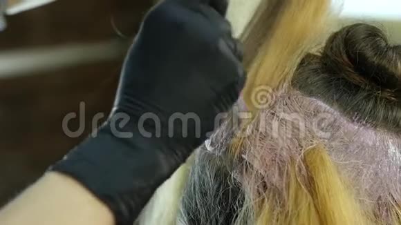 理发师为一个在美容院的青少年做发型和染色染的头发慢动作视频的预览图