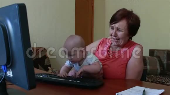 奶奶抱着孩子他玩电脑键盘视频的预览图