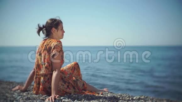可爱的女孩坐在沙滩上笑视频的预览图
