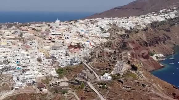 在希腊圣托里尼岛的奥亚镇的三个蓝色圆顶教堂周围飞行视频的预览图