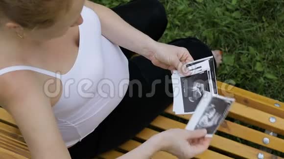 坐在长凳上看超声波扫描的孕妇视频的预览图