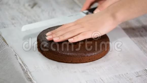 糕点厨师用刀子切巧克力海绵蛋糕视频的预览图