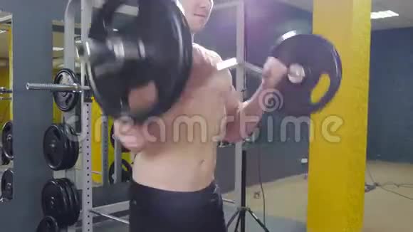 肌肉男在健身房锻炼用杠铃做二头肌视频的预览图