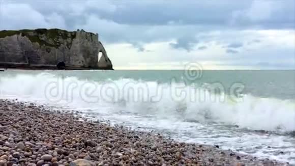 波浪在岩石附近的石滩上多云的天空视频的预览图
