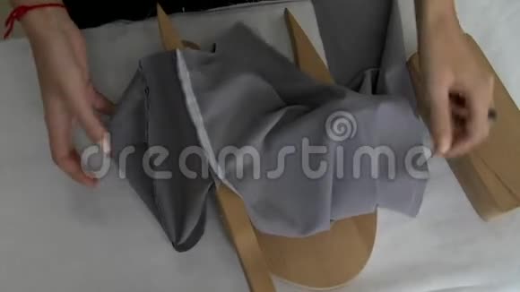 女性的双手展开灰色的织物来显示裤子上的接缝视频的预览图