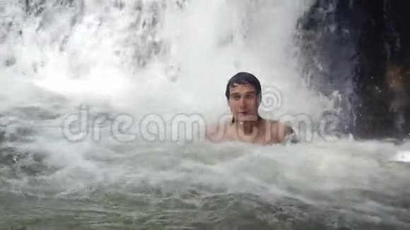 快乐的帅哥在热带丛林的瀑布下放松慢动作泰国1920x1080视频的预览图