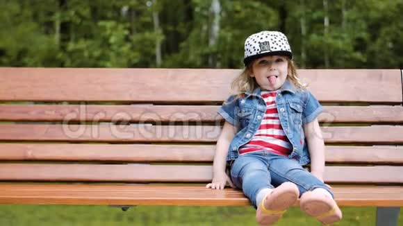 小女孩坐在长凳上微笑笑露出舌头视频的预览图