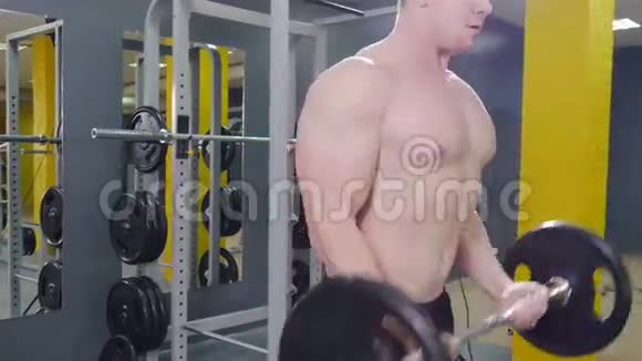 肌肉男在健身房锻炼用杠铃做二头肌视频的预览图