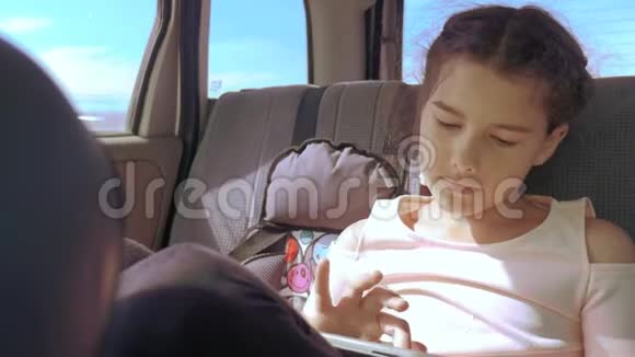 带着平板电脑的小女孩去美国德克萨斯旅行女孩生活方式汽车概念旅行交通视频的预览图