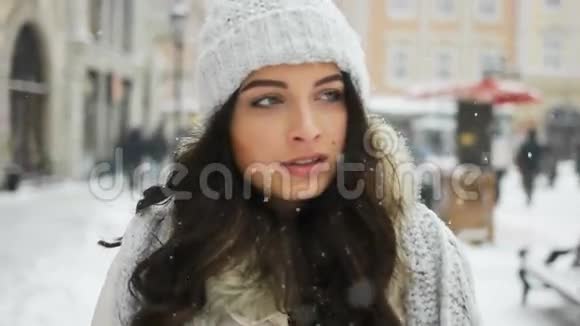 美丽迷人的女士走过白雪皑皑的城市背景视频的预览图