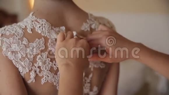 婚礼新娘的母亲在礼服上系扣子视频的预览图